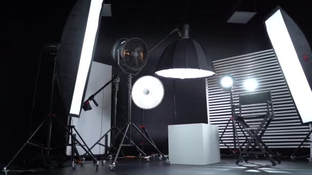 黑白相间的循环 黑暗的房间配备专业设备的现代摄影工作室 有照明设备的空照相馆 带有导演制作椅的现代摄影演播室内部 — 图库视频影像
