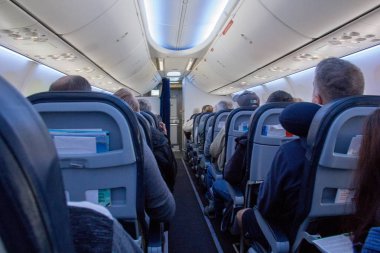 Ticari bir yolcu jeti üzerinde ekonomi sınıfının koridoraşağı bakıyor.