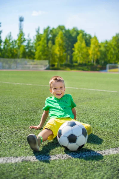 Positiv Pojke Barn Spelar Fotboll Fältet Royaltyfria Stockbilder