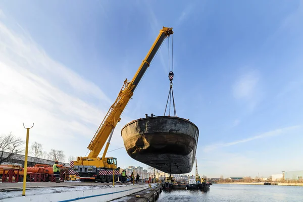 Rise of the vessel from the river on a winter shore park.