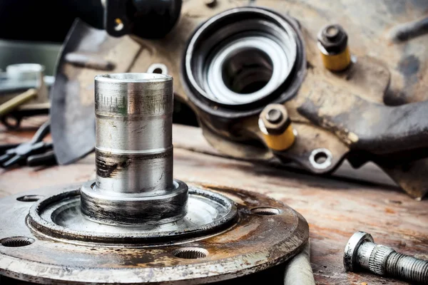 Old, oiled wheel hub lies on a wooden table