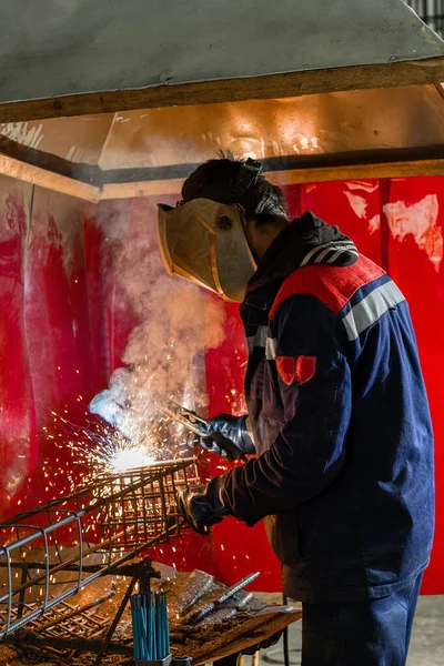 A welder is welding metal parts.