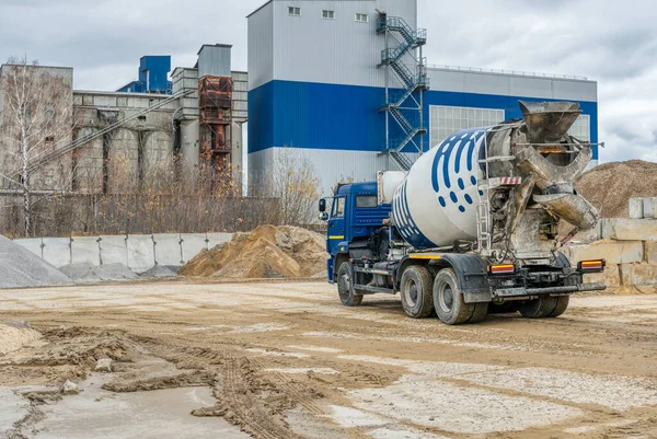 A concrete mixer truck transports concrete through a construction site.