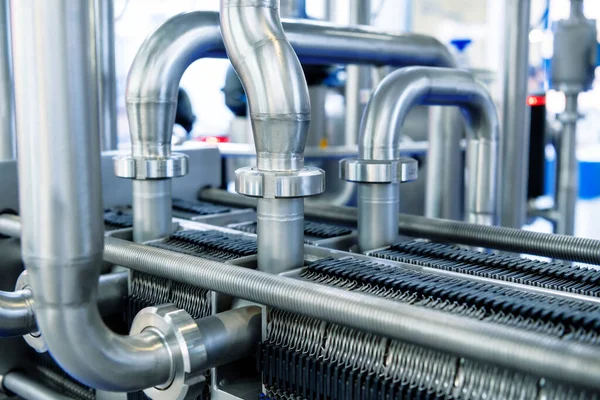 Industrial stainless steel piping connected by special nuts.