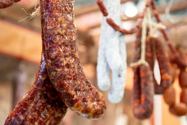 Many smoked sausages hanging on the ropes.