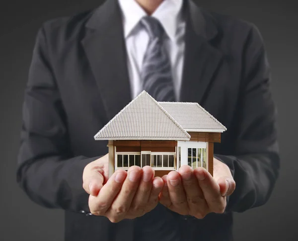 Huis in menselijke handen — Stockfoto