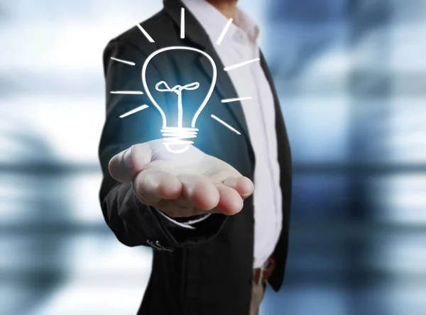 Business person holding light bulb — Stock Photo, Image