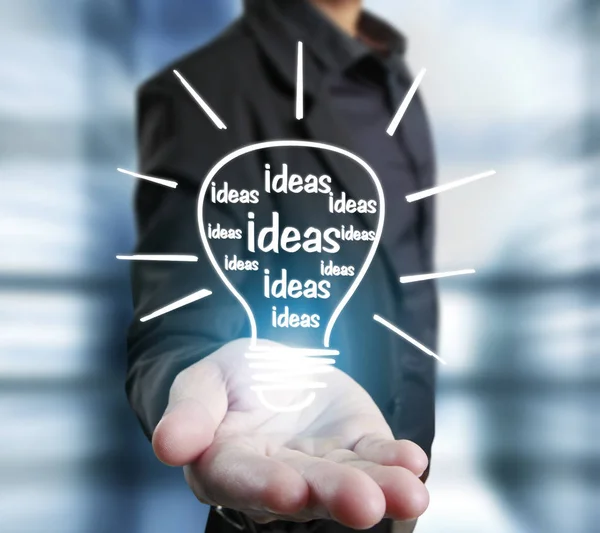 Business person holding light bulb — Stock Photo, Image
