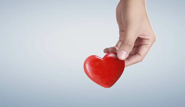 Mani con un cuore rosso, salute del cuore — Foto Stock