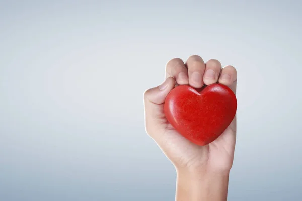 Χέρια κρατώντας μια κόκκινη καρδιά, την υγεία της καρδιάς — Φωτογραφία Αρχείου