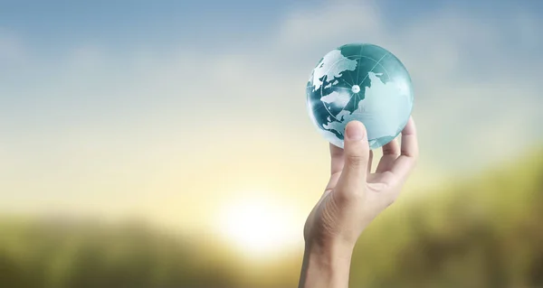 Глобус, земля в человеческой руке, держа нашу планету сияющей — стоковое фото