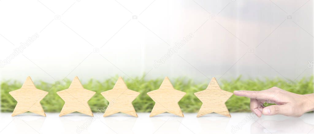 Wooden five star in hand shape. The best excellent business services rating customer experience concept