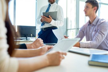 İş adamları modern ofiste patronuna sabah brifing sırasında dinleme tabloda toplantı oturan orta kesit görünümü