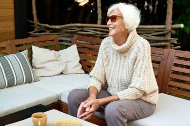 Neşeli kadın kıdemli portresi mutlu bir şekilde gülerek açık kafe salonda vaktinizi rahat örgü Kazak giymiş