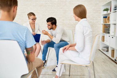 Destek grubu paylaşım kadın psikiyatrist ve sorunları diğer katılımcılar daire içinde ağlıyor genç adam portresi