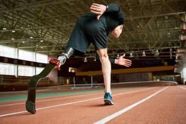 Isınma kararlı amputee sporcu portresi düşük açılı uygulama bacak germe modern spor salonunda çalıştırmadan önce yukarı