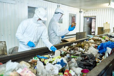 İki işçi biohazard giyen portresi işleme Konveyör bant, kopya alanı çöp sıralama tesisi atık çalışmaya uygun