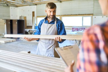Yetenekli marangoz ahşap atölyesinde, parça değerlendirmek en iyi malzeme seçimi portresi
