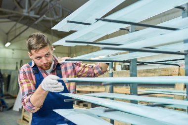 Endüstriyel atölye kalite, kopya alanı kontrol tribünde cam bölmeleri yerleştirerek mavi tulum giyen genç bir işçi portresi