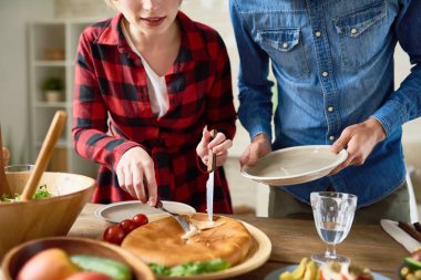 Modern genç çift ayakta şenlikli sofra kesme Gıda aile kutlama sırasında orta bölüm portresi