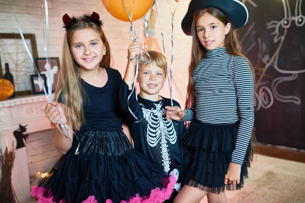Retrato Tres Niños Felices Con Disfraces Posando Con Globos Habitación — Foto de Stock