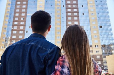 Genç çift geçmeden yeni apartman arayan kucaklayan portresi görünümü geri