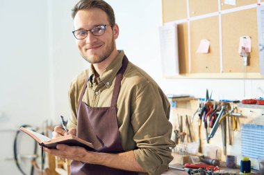 Çerçevede tablo araçları, kopya alanı ile el yapımı el sanatları Atölyesi Studio'da poz gülümseyen genç adam portresi