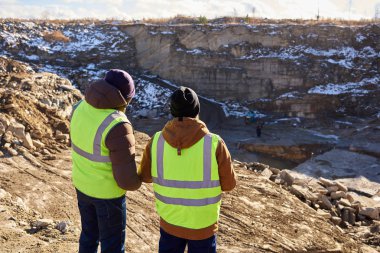 Yansıtıcı ceketler, onlardan biri Afrika, açık havada, şantiye üzerinde mineral maden bakan sarp kayalığın üzerinde kopya alanı ayakta giyen iki sanayi işçileri portresi görünümü geri