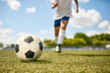 Futbol antrenmanı, çim üzerinde yalan top odaklanmak sırasında topu tekmeleme tanınmaz halde genç çocuk portresi düşük bölümü