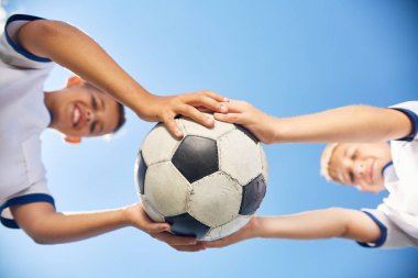 Mavi gökyüzü karşı topu tutan genç futbol takımının iki erkek portresi düşük açılı