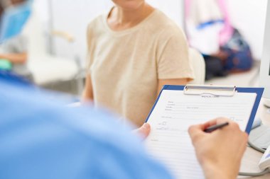 Bir doktor hasta belirtileri sağlık kartı içinde yazma Pano tutan kopya alanı