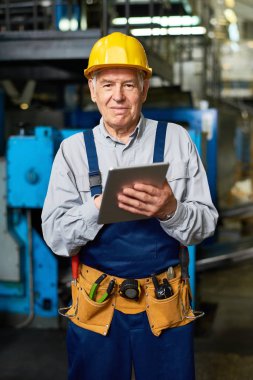 Dijital tablet kullanma ve modern atölyede poz fotoğraf gülümseyen kıdemli fabrika işçisi portresi