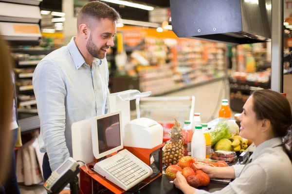 Portret Przystojny Młody Człowiek Kupując Jedzenie Stojący Supermarkecie Kasie Uśmiechający — Zdjęcie stockowe