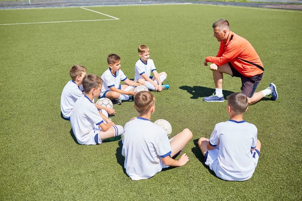 Junior Squadra Calcio Seduto Intorno Allenatore Ascoltandolo Campo Nella Giornata — Foto Stock