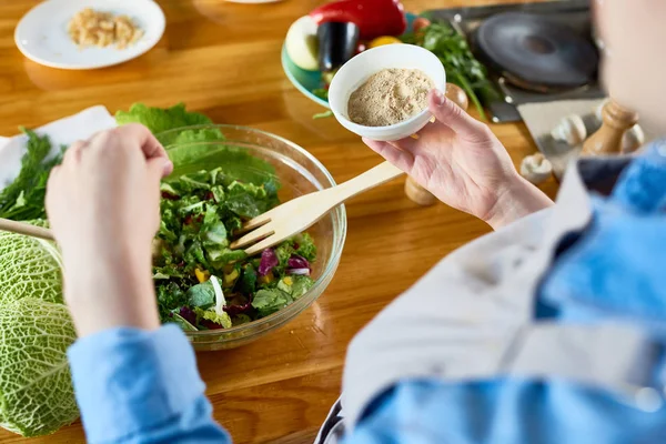 Añadir condimento a la ensalada — Foto de Stock