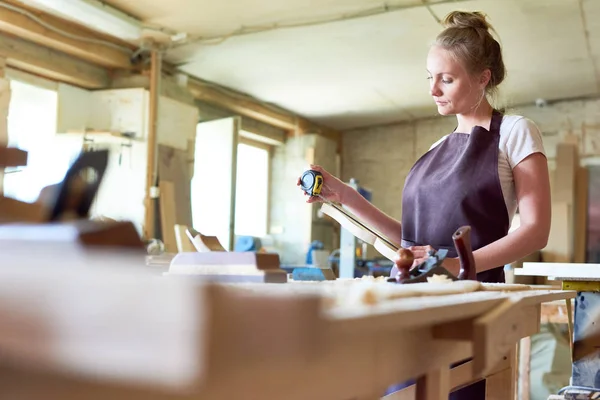 Porträtt Ung Kvinna Som Arbetar Snickare Shop Mäta Träbit Samtidigt — Stockfoto