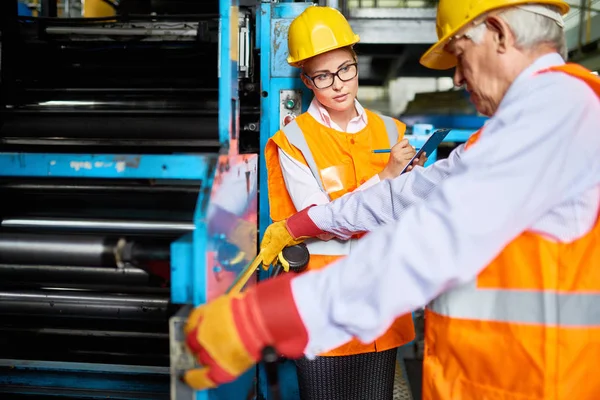 Porträtt Ung Kvinna Anteckningar Medan Tittar Senior Fabriksarbetare Löpande Maskiner — Stockfoto