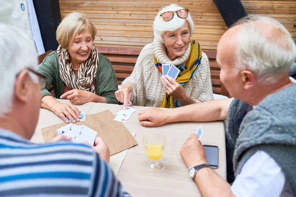 Two Senior Couples Wearing Warm Clothes Playing Card Each Other — Stock Photo, Image