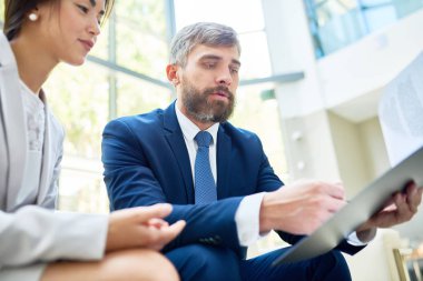 Başarılı çalışmaları geniş ofis lobisinde panoramik pencerelere ile çalışma toplantısı sırasında sonuçlarını analiz konsantre beyaz yakalı işçilerin düşük açılı görünüş