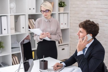 Resepsiyon ofiste çalışan, telefonla konuşma ve notlar bekleyen sekreteriyle yapma meşgul manager portresi