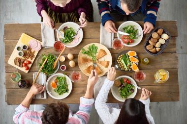 Dört arkadaş kafe ya da Restoran kutlamanın lezzetli yemekleri ile şenlikli yemeği masada yemek Üstten Görünüm