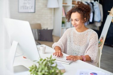 Çalışma from home ile modern daire içinde bilgisayar masasında gülümseyen genç kadın portresi