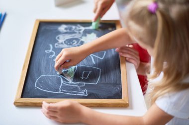 Masada oturan ve ilgi ile kara tahta üzerinde çizim tanınmaz halde çocukların yakın çekim shot