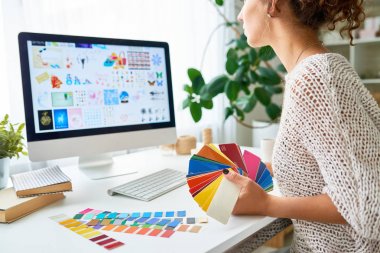 Orta kesit portre genç yaratıcı tasarımcı çalışma masasında modern ofis renk paleti örneklerini seçme