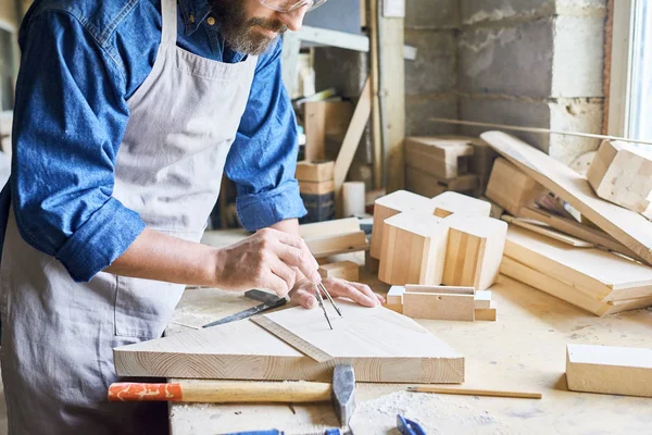 在木匠车间制作家具上用测量仪器标记木头的结实男性手的特写画像 — 图库照片