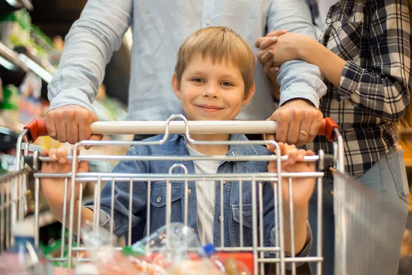 Portret Szczęśliwy Młody Chłopak Zakupy Spożywcze Supermarkecie Wraz Rodzicami Pchania — Zdjęcie stockowe