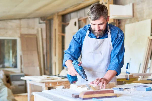 Portrait Mature Bearded Carpenter Drilling Wooden Part While Making Furniture — Stock Photo, Image
