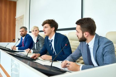 Satır için mikrofon konuşma medya soruları yanıtlayan basın toplantısında siyasi tartışmaya katılan oturan birkaç iş insanlar portresi