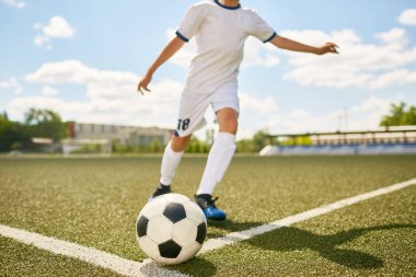 Alan açık havada futbol antrenmanı sırasında topu tekmeleme tanınmaz halde genç çocuk portresi