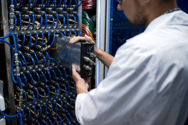 Süper bilgisayarla çalışırken blade sunucu alarak laboratuar önlüğünü tanınmayan adam portresi görünümü geri